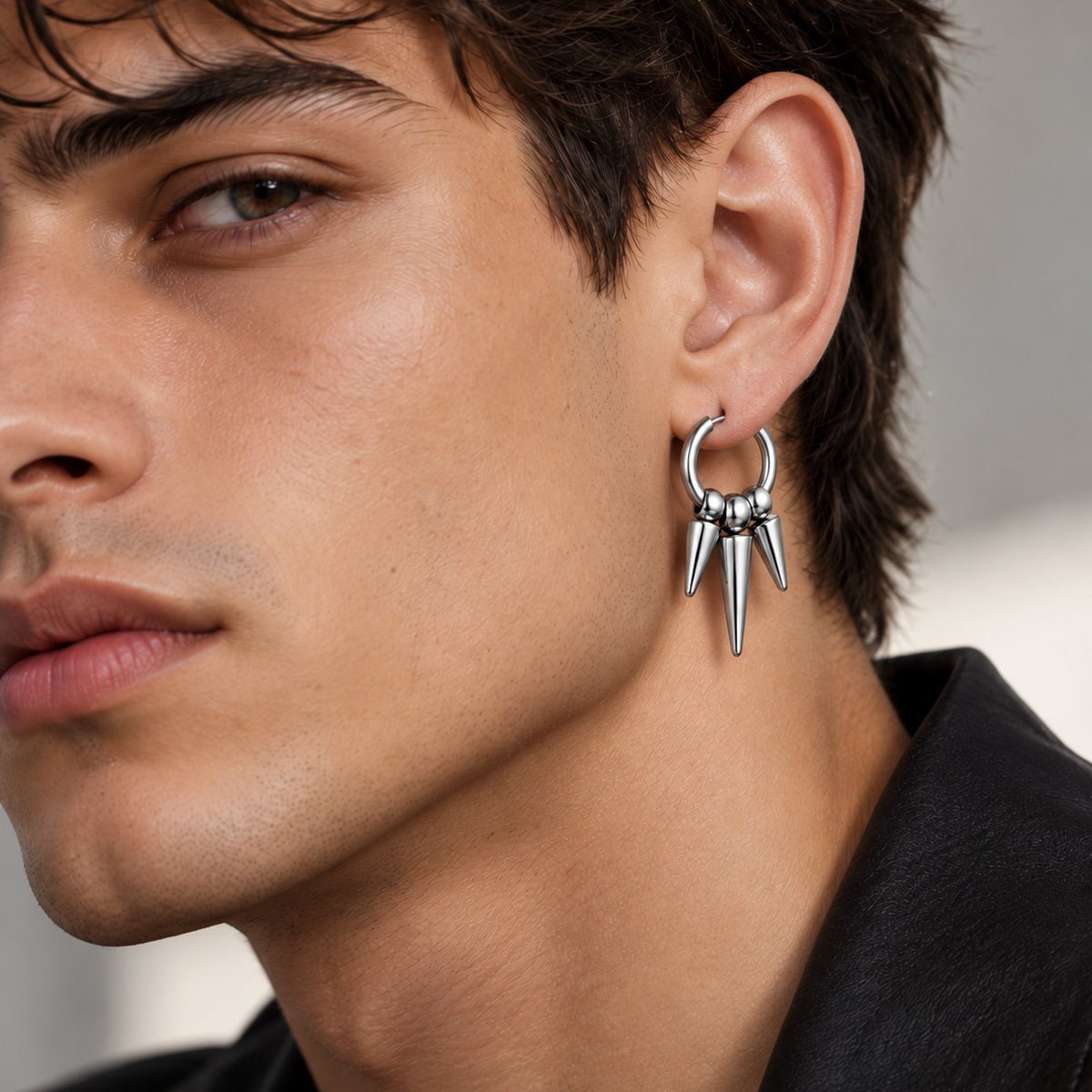 Close-up of the Abraham Firestone triple-spike hoop earring shown at a model's ear