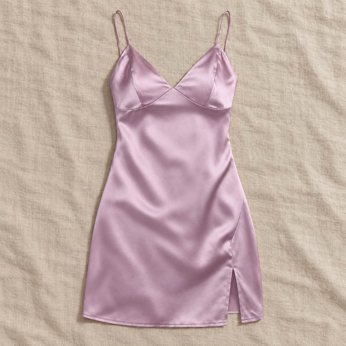 Pink Amari Combs satin mini slip dress laid flat on a beige fabric surface.