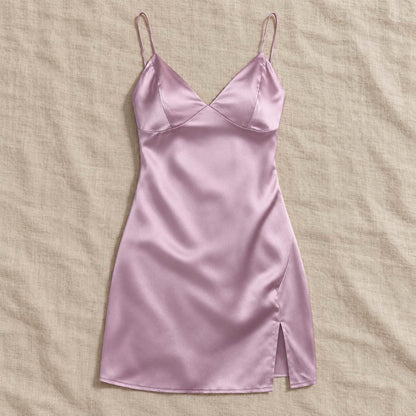 Pink Amari Combs satin mini slip dress laid flat on a beige fabric surface.