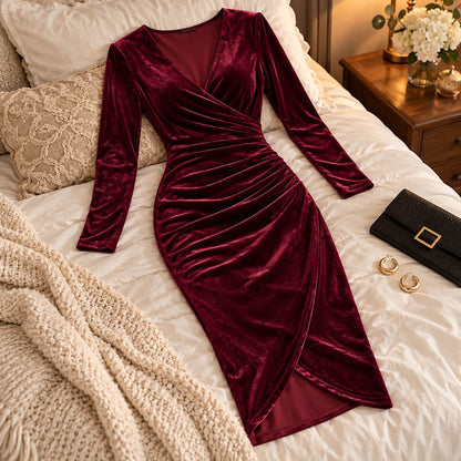 Amory wine red velvet midi dress arranged on a styled bed in an elegant bedroom.