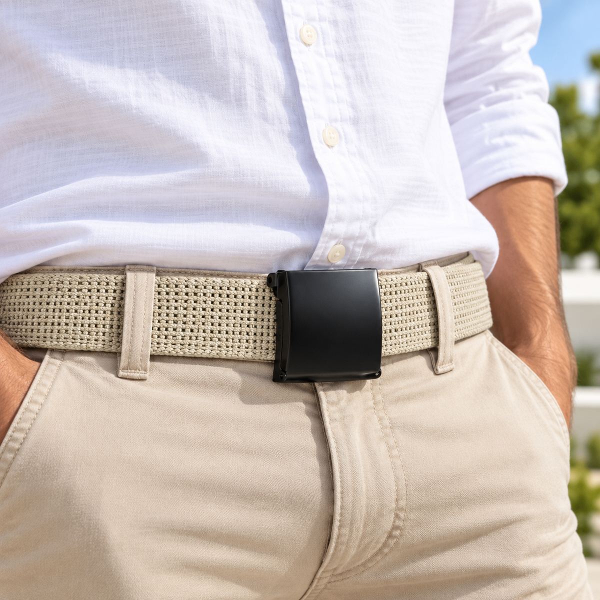Beige woven belt with a black buckle, worn with a white shirt and beige trousers.
