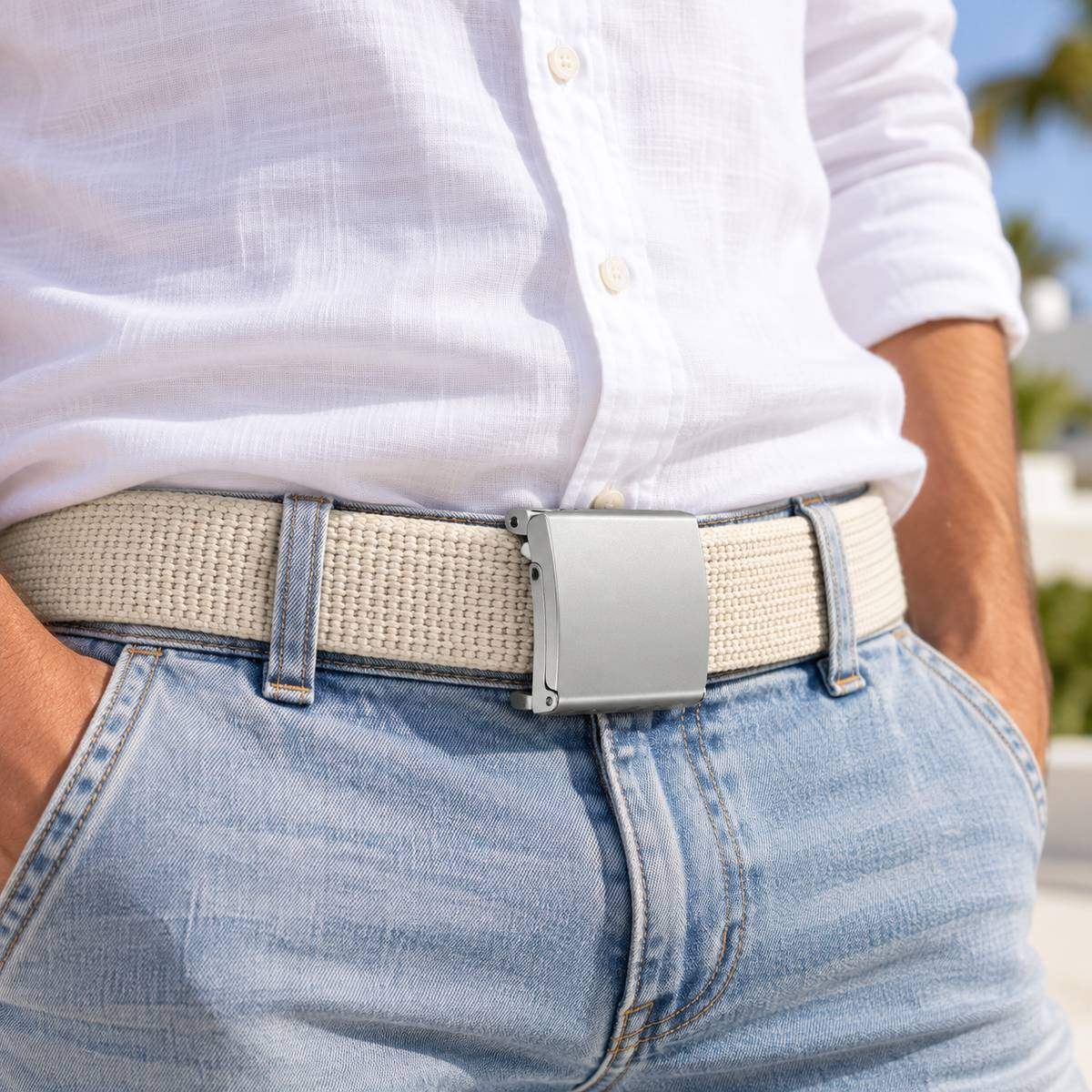 Beige woven belt with a silver buckle, worn with a white shirt and light blue jeans.