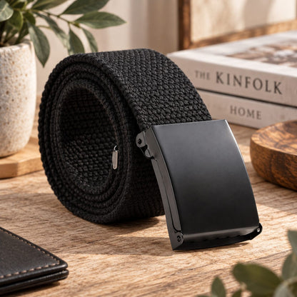Black woven belt arranged in a coil with its black buckle facing forward.