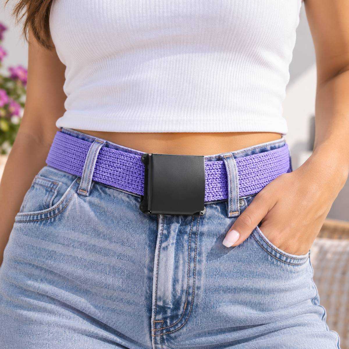 Purple woven belt with a black buckle, worn with a white top and light blue jeans.