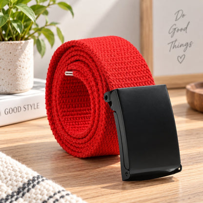 Red woven belt arranged in a coil with its black buckle facing forward.