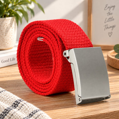Red woven belt arranged in a coil with its silver buckle facing forward.